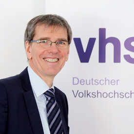 Ulrich Aengenvoort vor dem Logo des DVV