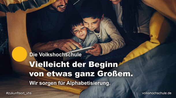 Eine Frau und ein Mann lesen mit ihren beiden Kindern unter einem Zelt.