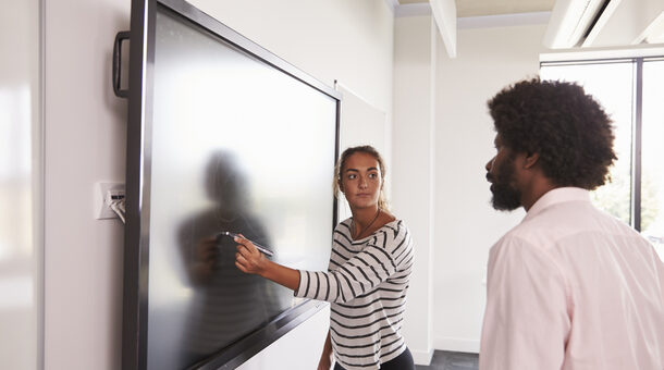 Kursteilnehmer und Dozentin arbeiten gemeinsam an einem digitalen Whiteboard