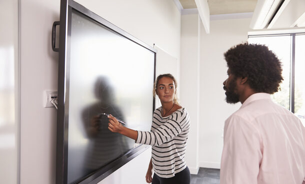Kursteilnehmer und Dozentin arbeiten gemeinsam an einem digitalen Whiteboard
