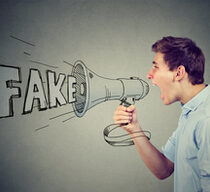 Ein junger Mann schreit in ein Megaphon und verbreitet Fake News