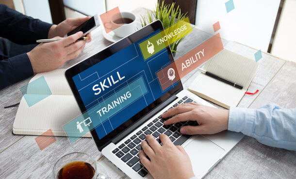 Laptop-Bildschirm auf dem die Worte "Skill", "Knowledge", "Ability" und "Training" zu lesen sind.
