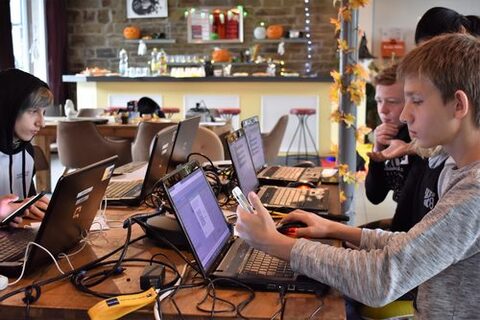 Jugendliche lernen Programmieren mit Smartphone und Laptop