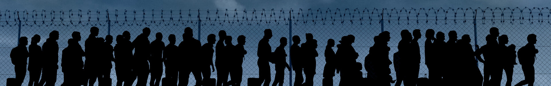 Column of migrants near the state borders. Fence and barbed wire. Surveillance, supervised. Refugees and immigrants