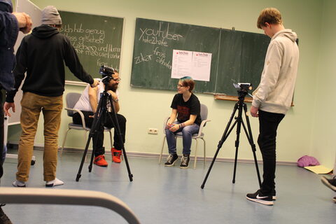 Workshopteilnehmer*innen interviewen YouTube-Star Firas Alshater.