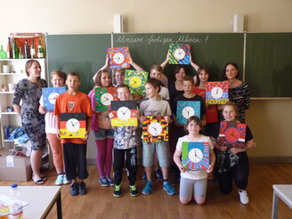 Gruppenbild: Die Kinder zeigen selbstgestaltete Wanduhren