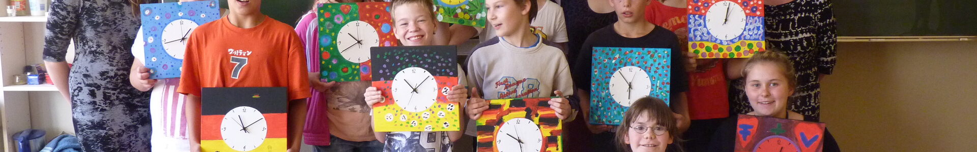 Gruppenbild: Die Kinder zeigen selbstgestaltete Wanduhren