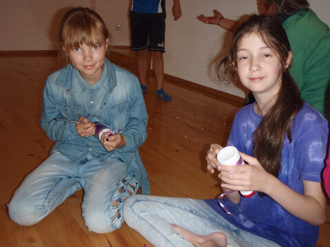 Mädchen sitzen auf dem Boden.