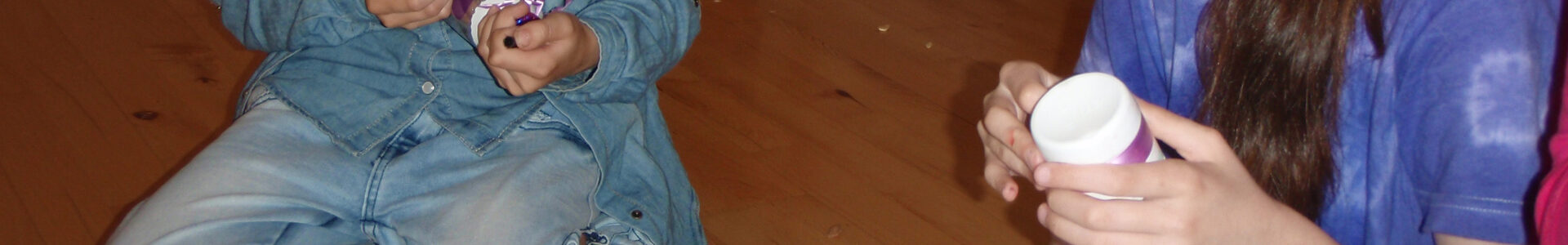 Mädchen sitzen auf dem Boden.