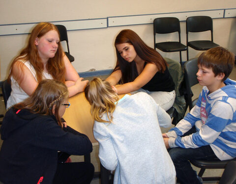 Teilnehmende arbeiten gemeinsam am Tisch