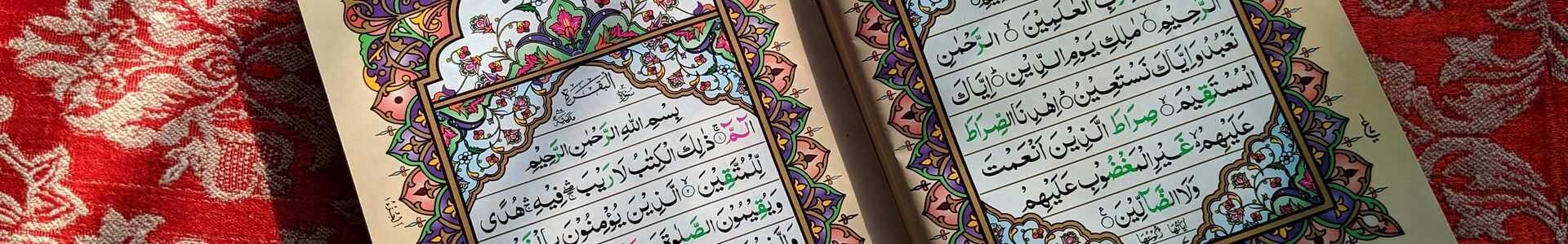 Ein aufgeklappter Koran mit arabischen Schriftzeichen und bunten Verzierungen