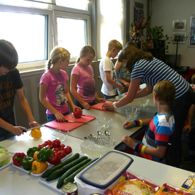 Kinder bereiten Essen zu.