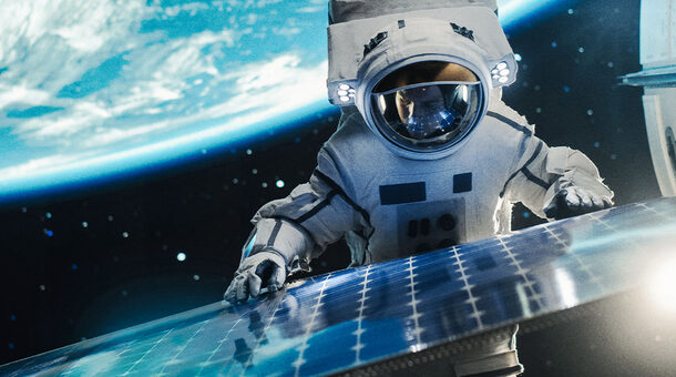 Ein Astronaut im Raumanzug arbeitet im Weltraum an einem Solarpanel. Im Hintergrund die Erde und das All.