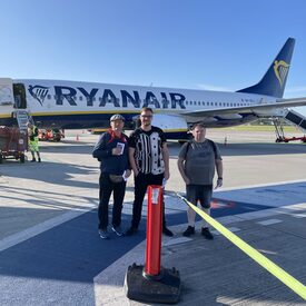 3 Männer stehen auf dem Rollfeld vor einem Flugzeug von Ryanair