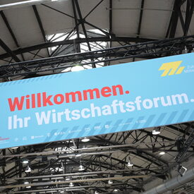 Banner am Eingang des Zukunfttages Mittelstand mit der Aufschrift: Willkommen. Ihr Wirtschaftsforum.