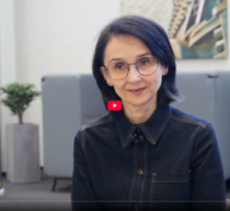 Frauen sitzen an einem Tisch und lernen gemeinsam mit zwei Kursleitungen, die an einem Flipchart stehen.