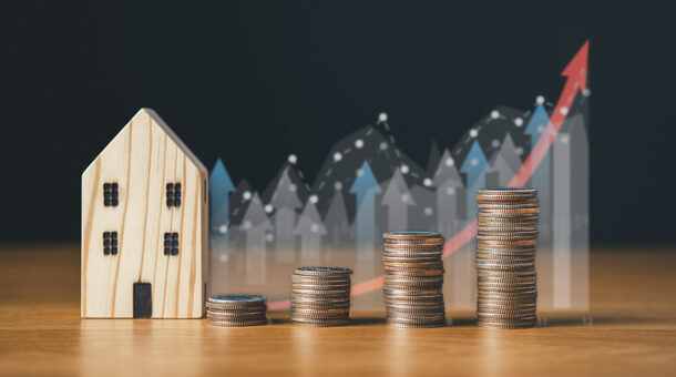 real estate investing and saving money concept.coins stack with house icon and background.