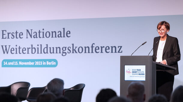 Bundesbildungsministerin Bettina Stark Watzinger steht bei der Nationalen Weiterbildungskonferenz am 14. und 15. November 2023 am Podium.