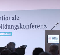 Bundesbildungsministerin Bettina Stark Watzinger steht bei der Nationalen Weiterbildungskonferenz am 14. und 15. November 2023 am Podium.