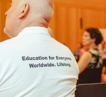Fotos des Rückens eines Mannes, auf dessen T-Shirt steht "Education für Everyone. Worldwide. Lifelong.